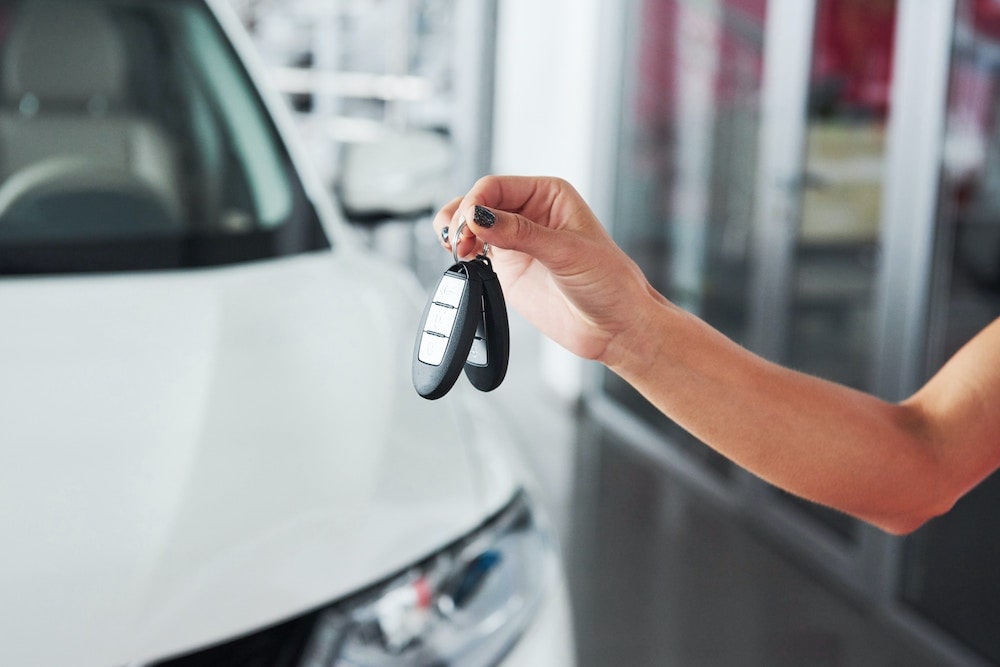 The Hidden Profits of Dealer Reinsurance 1 Person holding car keys to depict selling auto dealer reinsurance.